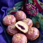 pączki lukrowane na talerzu jeden z nich przekrojony ukazujący nadzienie